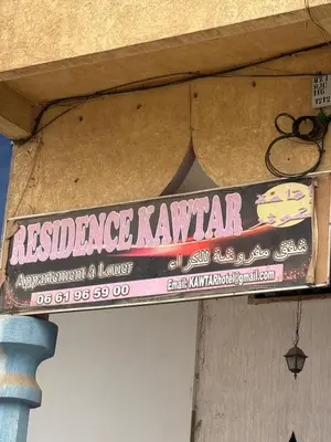 a sign on the side of a building at hôtel kawtar in Meknès
