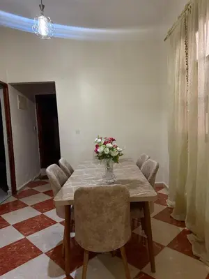 a dining room table with a vase of flowers on it at hôtel kawtar in Meknès