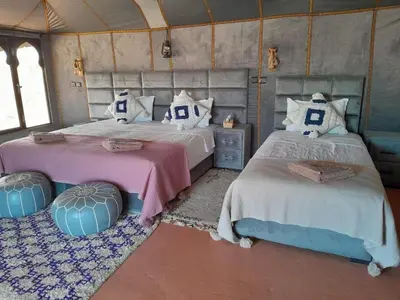 a bedroom with two beds with pillows at Merzouga Solace Luxury Camp in Merzouga