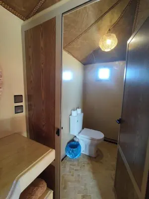 a small bathroom with a toilet and a shower at Merzouga Solace Luxury Camp in Merzouga