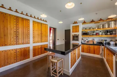 a kitchen with wooden cabinets and a black counter top at Villa Chocolat Deluxe in Marrakech