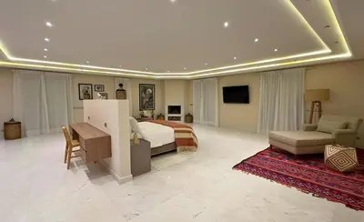 a large bedroom with a bed and a living room at Villa Chocolat Deluxe in Marrakech