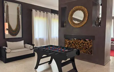 a living room with a table and a fireplace at Villa Chocolat Deluxe in Marrakech