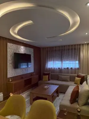 a living room with a couch and a tv at Un bel appartement in Oulad Akkou