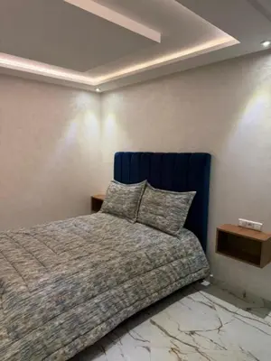 a bedroom with a bed with a blue head board at Un bel appartement in Oulad Akkou
