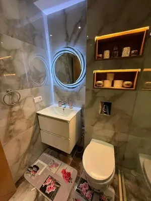 a bathroom with a toilet and a sink and a mirror at Un bel appartement in Oulad Akkou