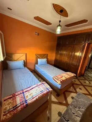 two twin beds in a room with at Maison vacancier in Oulad Akkou