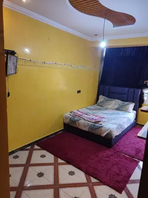 a bedroom with a bed and a yellow wall at Maison vacancier in Oulad Akkou
