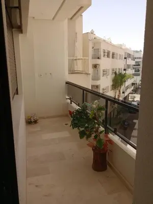 a balcony of a building with a potted plant at Résidence les princesses champs de course in Fès