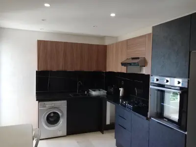 a kitchen with black counters and a washer and dryer at Résidence les princesses champs de course in Fès