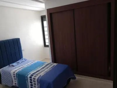 a bedroom with a bed and a large closet at Résidence les princesses champs de course in Fès