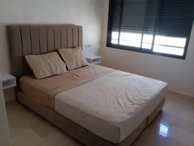 a bedroom with a large bed with two pillows and a window at Résidence les princesses champs de course in Fès
