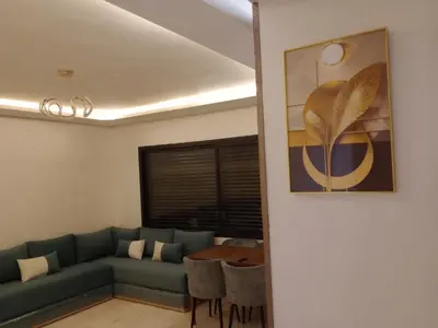 a living room with a couch and a table at Résidence les princesses champs de course in Fès