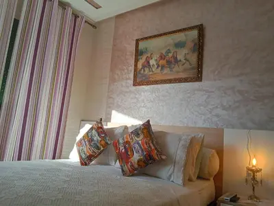 a bedroom with a bed with pillows and a painting on the wall at Résidence Al Qaraouiyine in Fès