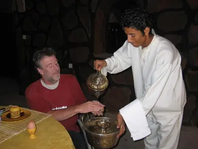 two men are mixing something in a bowl at Rose du Sable in Agdz