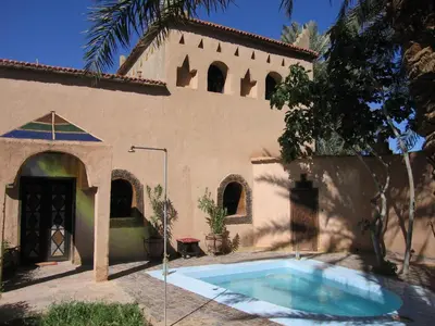 a house with a swimming pool in front of it at Rose du Sable in Agdz