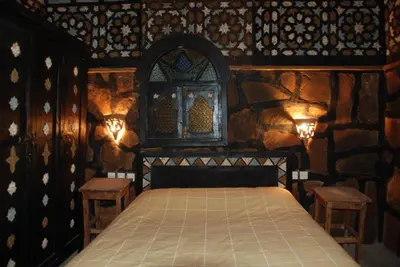 a bedroom with a bed in a stone wall at Rose du Sable in Agdz