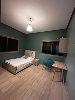 a bedroom with a bed and a table and windows at Villa Lina in Meknès