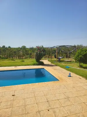 a swimming pool in a yard with a playground at Villa Lina in Meknès