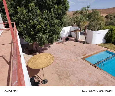 a patio with a table and a swimming pool at Ferme d'hôtes Aghbalou in Sefrou