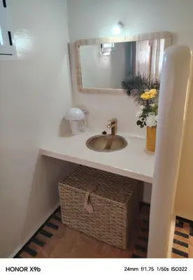 a bathroom with a sink and a basket under a counter at Ferme d'hôtes Aghbalou in Sefrou
