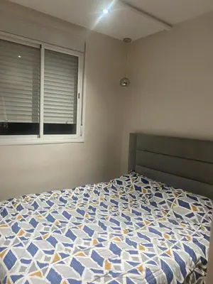 a bedroom with a blue and white bed with a window at Bel appartement à louer in Ifrane