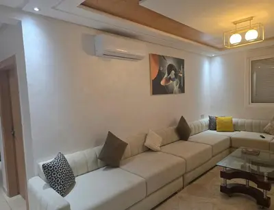 a white living room with a couch and a table at Bel appartement à louer in Ifrane