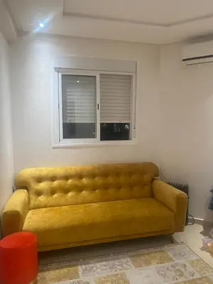 a yellow couch in a living room with a window at Bel appartement à louer in Ifrane