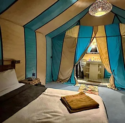 a bedroom with a bed with a tent at Sahara Authentic Camp in Merzouga