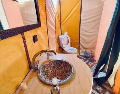 a bathroom with a sink and a toilet in a tent at Sahara Authentic Camp in Merzouga