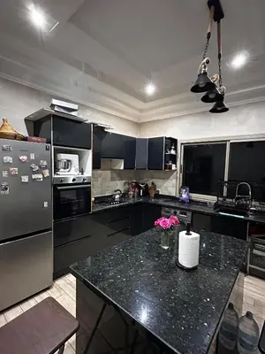 a kitchen with black cabinets and a black counter top at Villa élégante in Aït Ali Ou Moussa