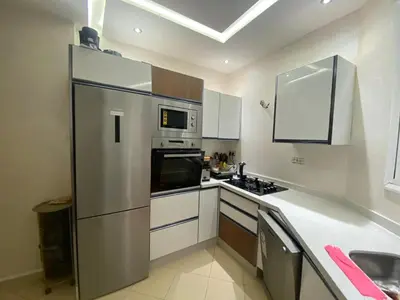 a kitchen with a refrigerator and a stove top oven at Appartement luxueux in Ifrane
