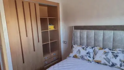 a bedroom with a bed next to a closet at Appartement luxueux in Ifrane