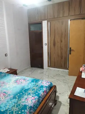 a bedroom with a bed and wooden cabinets at Location AZROU in Azrou