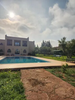 a swimming pool in front of a house at La dolce villa in Sidi Bouzguia