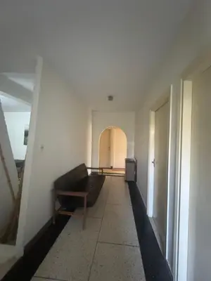 a living room with a couch and a hallway at Maison traditionnelle