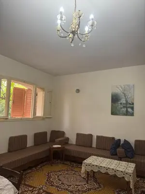a living room with a couch and a chandelier at Maison traditionnelle