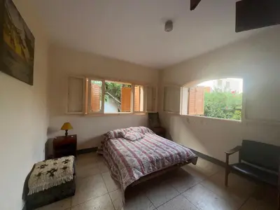 a bedroom with a bed and two windows at Maison traditionnelle