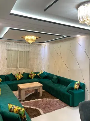 a living room with a green couch and a table at Cozy apartment in Ifrane in Ifrane