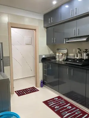 a kitchen with black cabinets and a white door at Cozy apartment in Ifrane in Ifrane