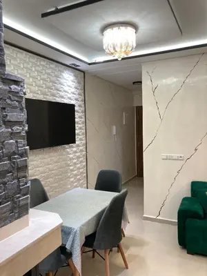 a dining room with a table and chairs and a wall at Cozy apartment in Ifrane in Ifrane
