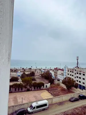 a white van parked in a parking lot next to the ocean at Apartment in Ouedlaou in Oulad Akkou