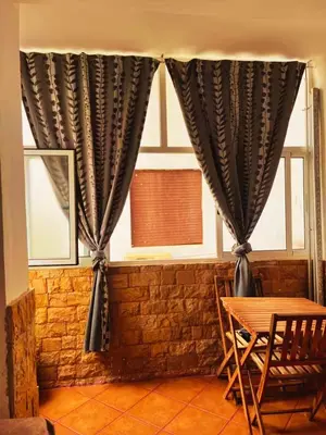 a table and chairs in front of a window at Apartment in Ouedlaou in Oulad Akkou