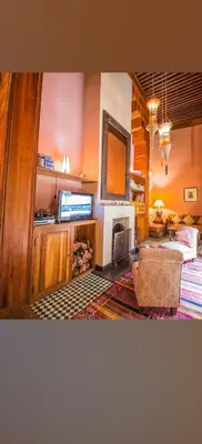 a living room with a bed and a fireplace at Riad Victoria in Fès
