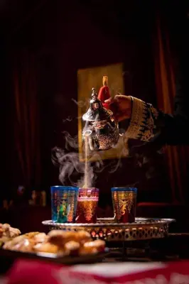 a person is sprinkling smoke on a table with food at Riad Victoria in Fès