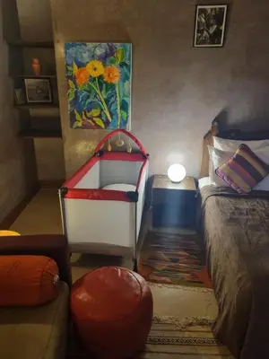 a bedroom with a bed and a chair and a painting at Riad Victoria in Fès