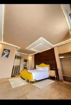 a bedroom with a large bed with a yellow headboard at Auberge rahha