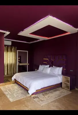 a bedroom with a large white bed with purple walls at Auberge rahha