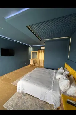 a bedroom with a large bed with a blue wall at Auberge rahha