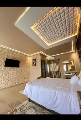 a bedroom with a large white bed and a television at Auberge rahha